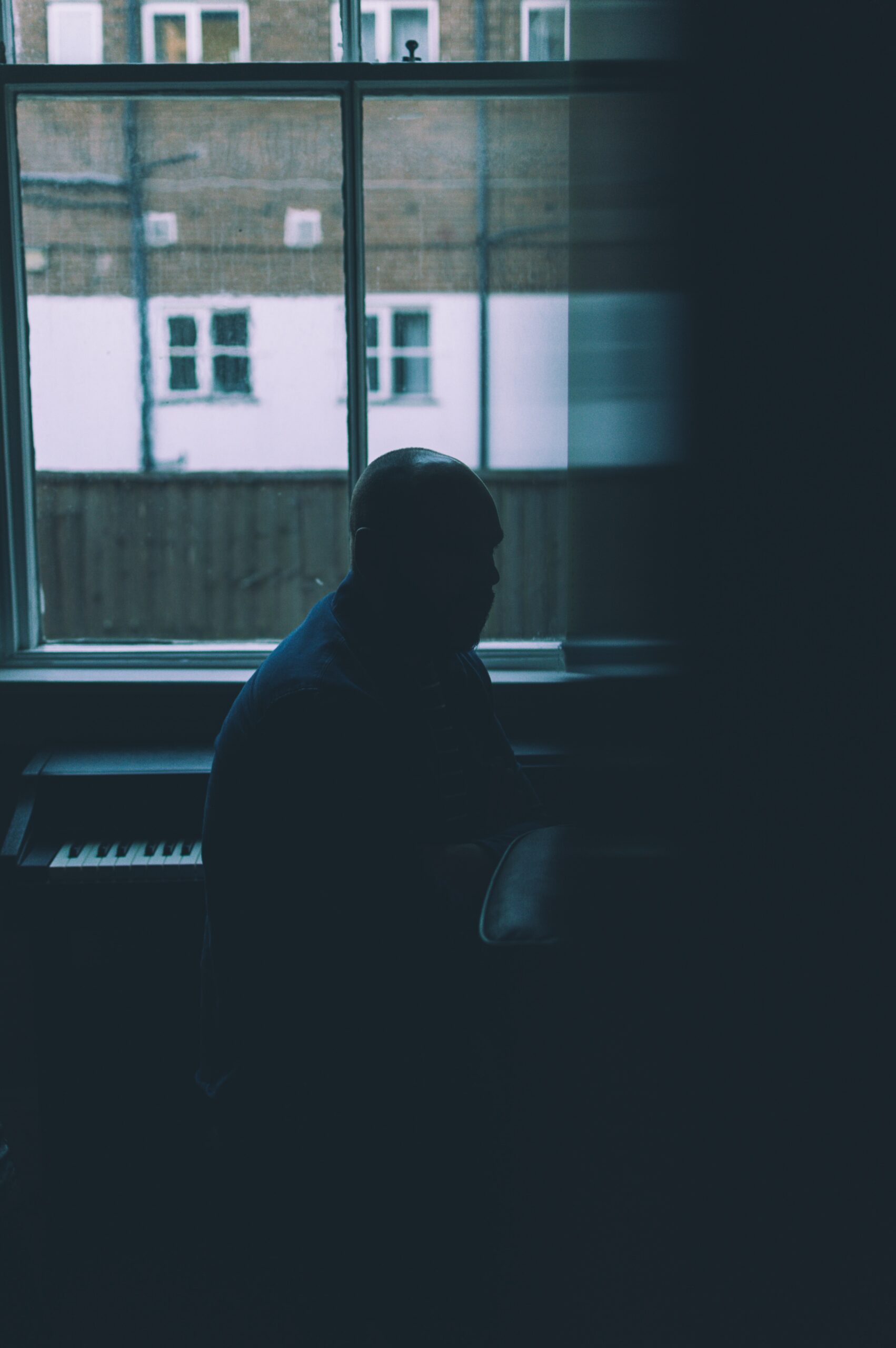 man sitting near piano inside room by elliot man on Unsplash