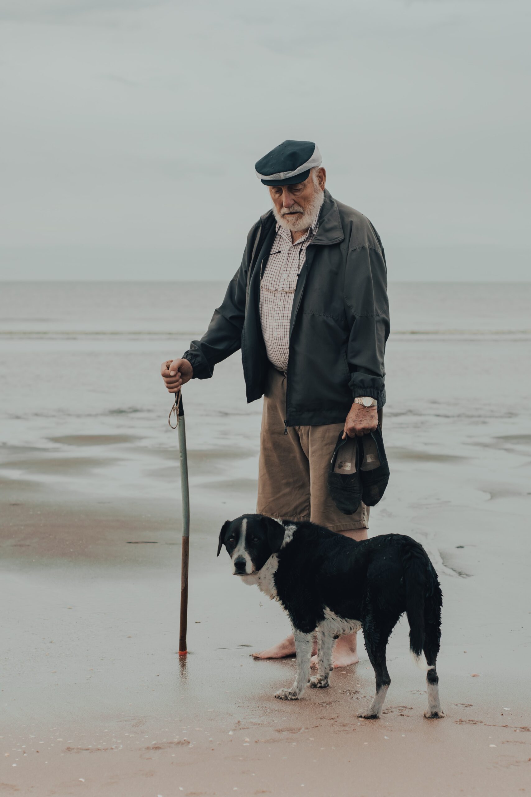 gaspar-manuel-zaldo-Older bearded gentleman with hat grey coat and dog at side-unsplash