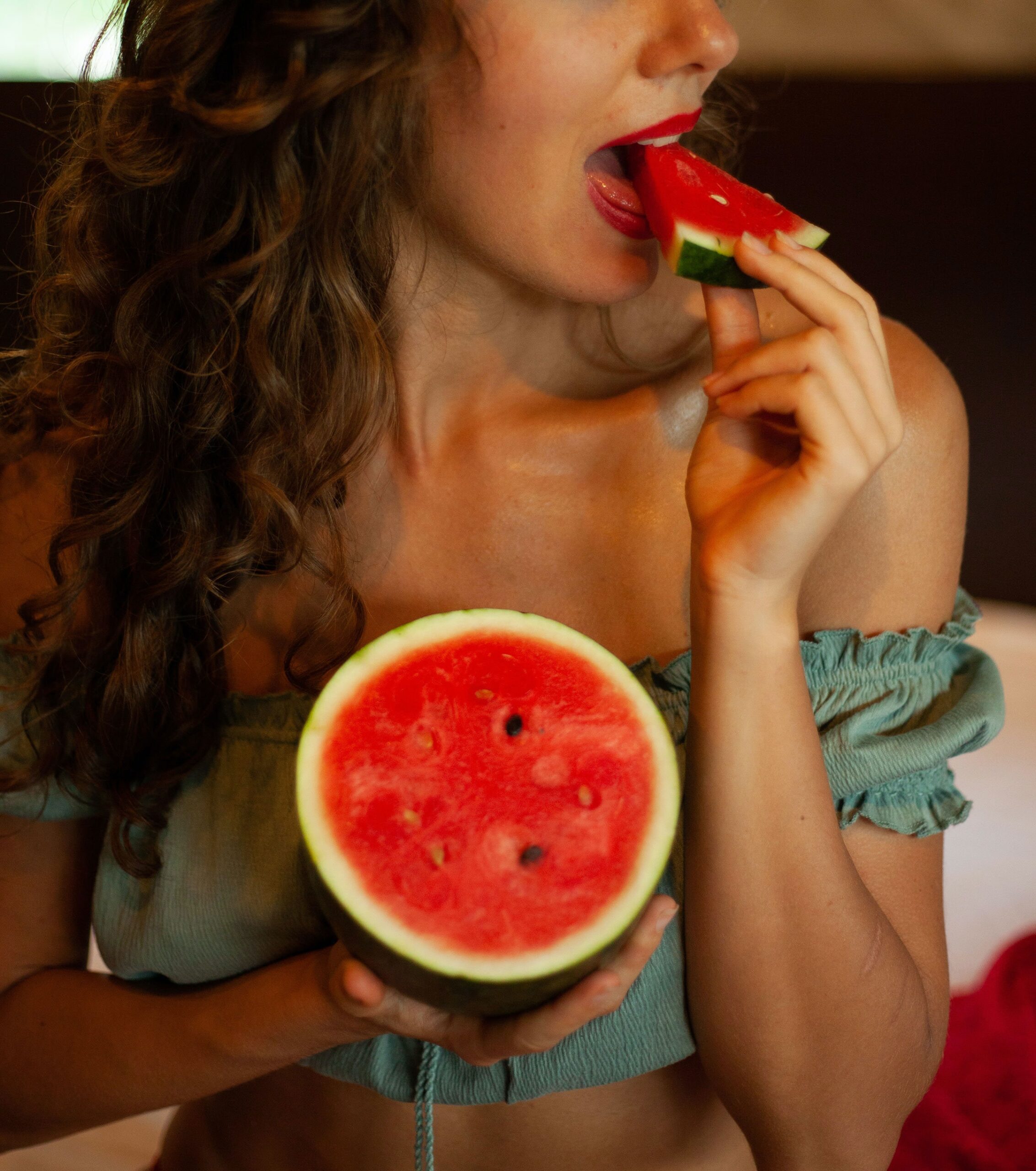 dainis-graveris-Woman eating mini watermelon half-unsplash