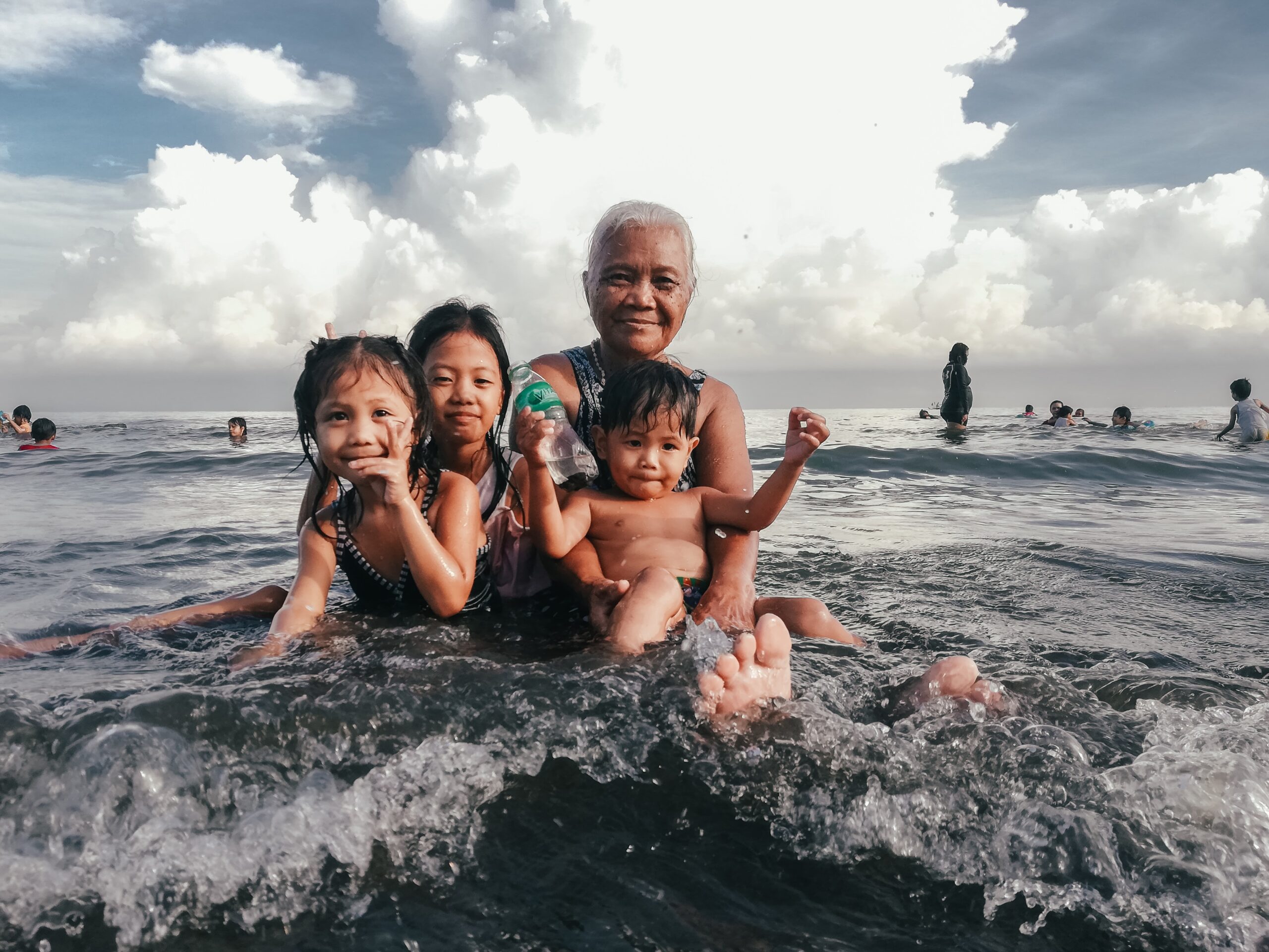 Grandmother with grandchildren in the surf by Jove Duero Unsplash
