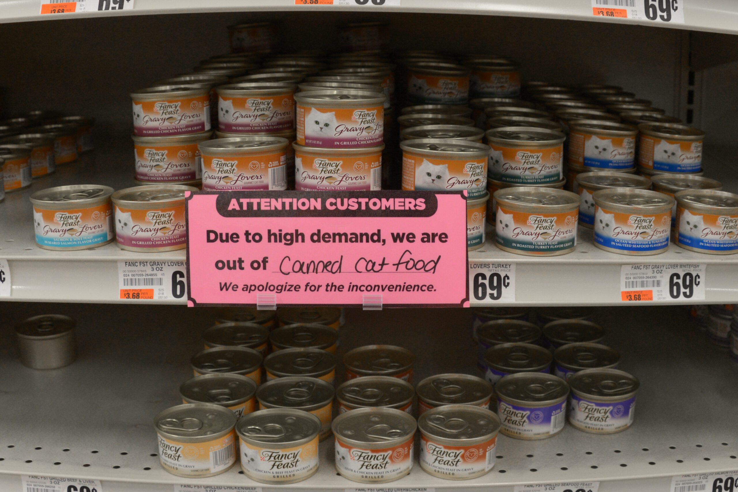 Two Shelves of full of Fancy Feast canned cat food with sign indicating due to high demand we are out of canned cat food by Franklin Crawford