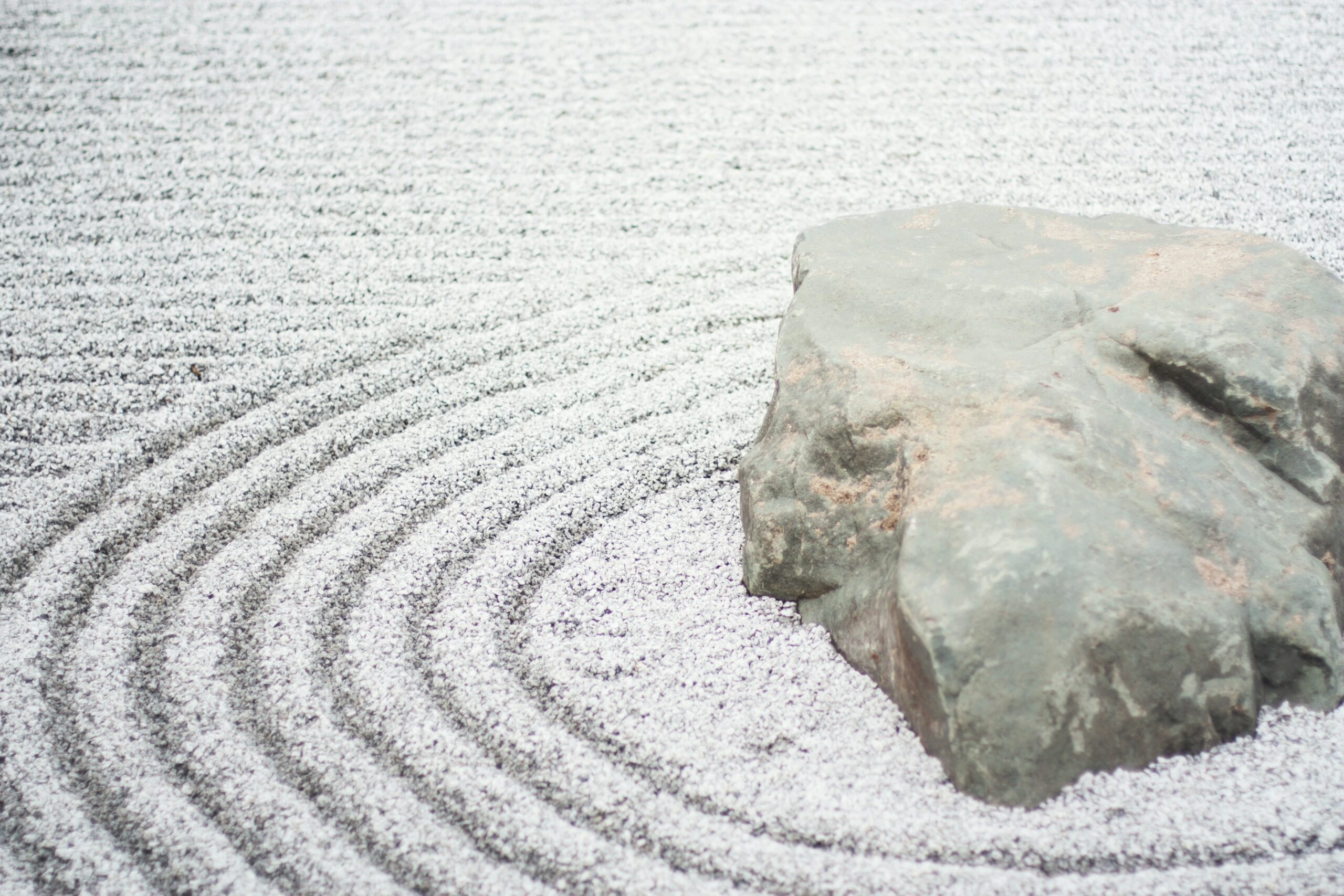 Zen Rock Garden with concentric circles in sand made by rake by Kari Shea on Unsplash