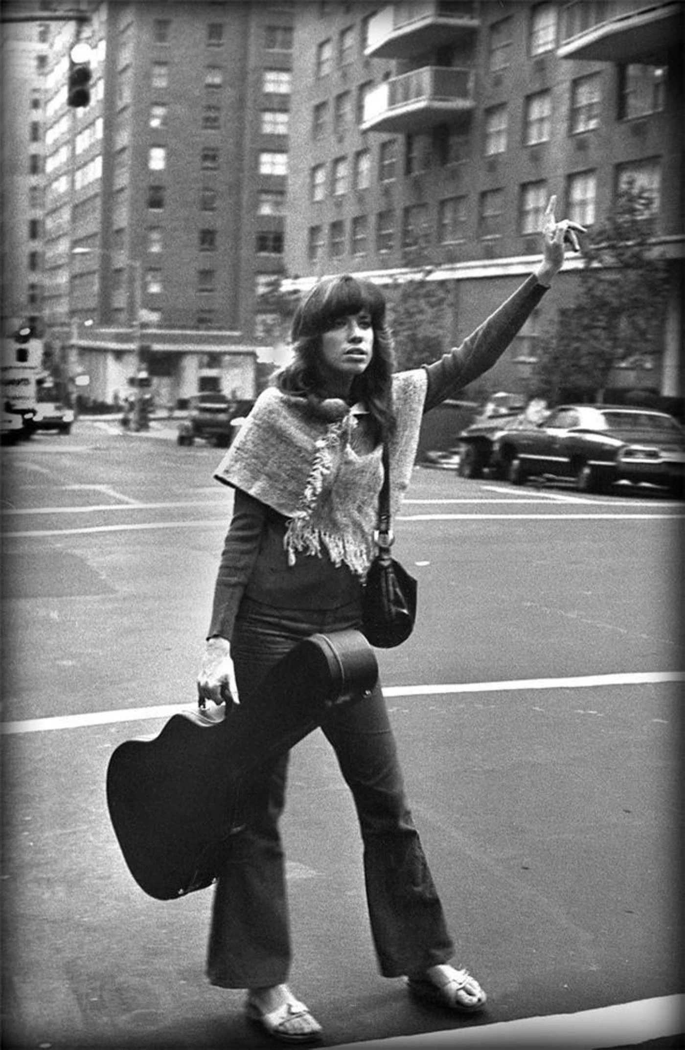 Carly Simon in Brooklyn with guitar in hand hailing cab