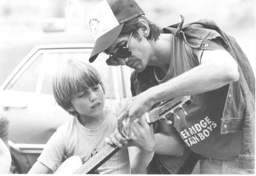 Townes Van Zandt with young boy showing how to pick chords