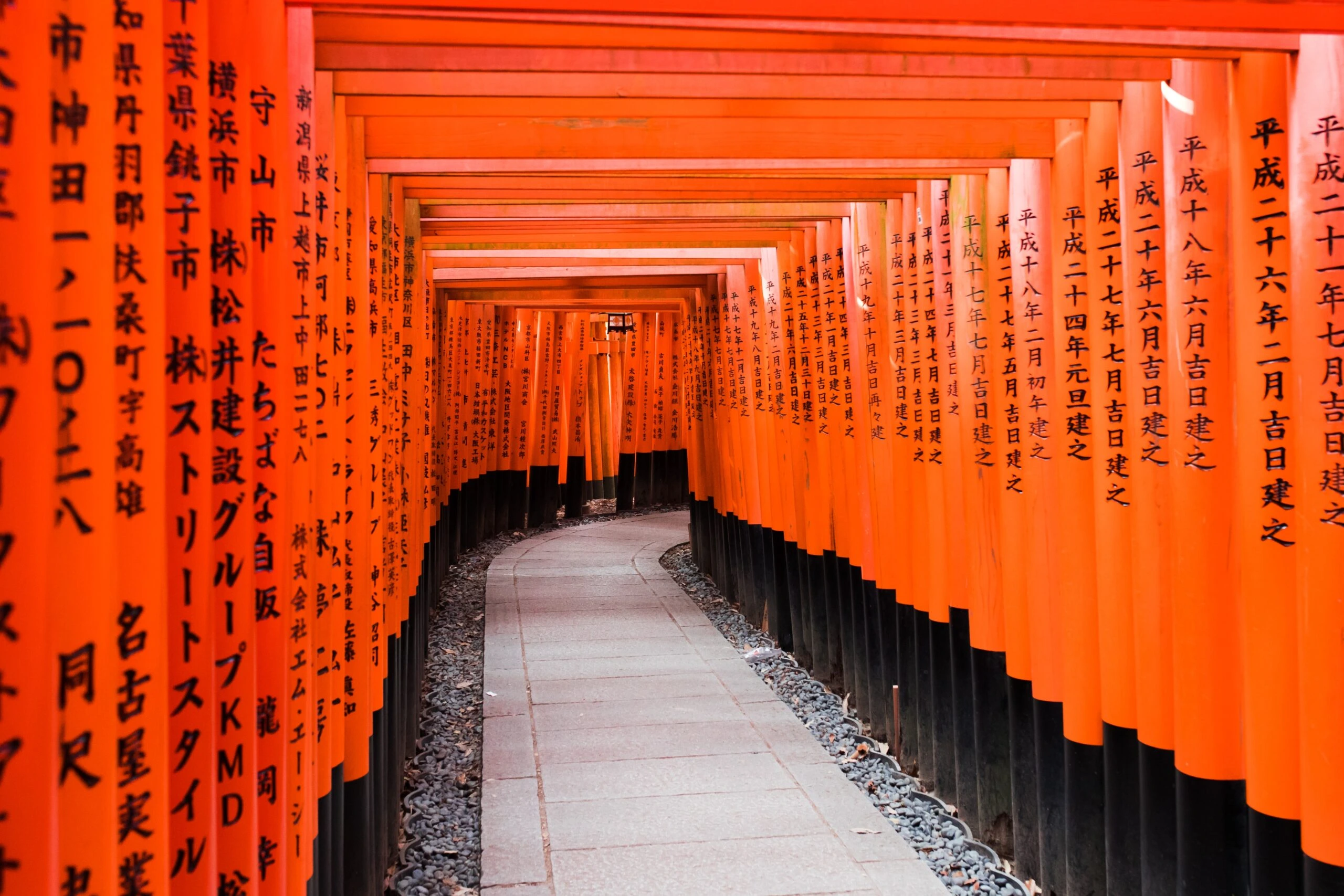 billy-pasco-Orange scroll walls with Japanese calligraphy forming walls with concrete paved path between-unsplash