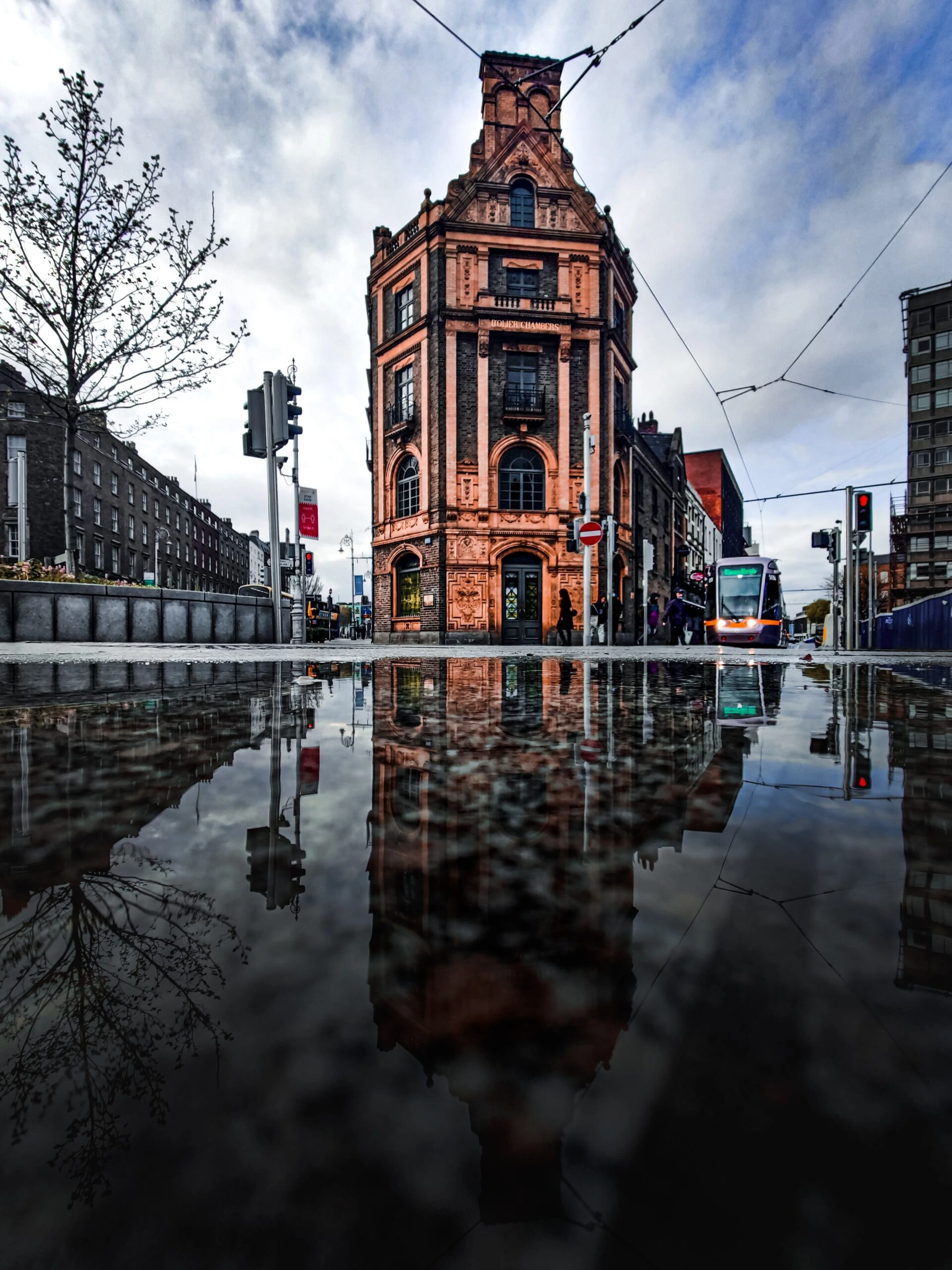 conor-luddy-Dublin city street level after rain with metro in frame-unsplash