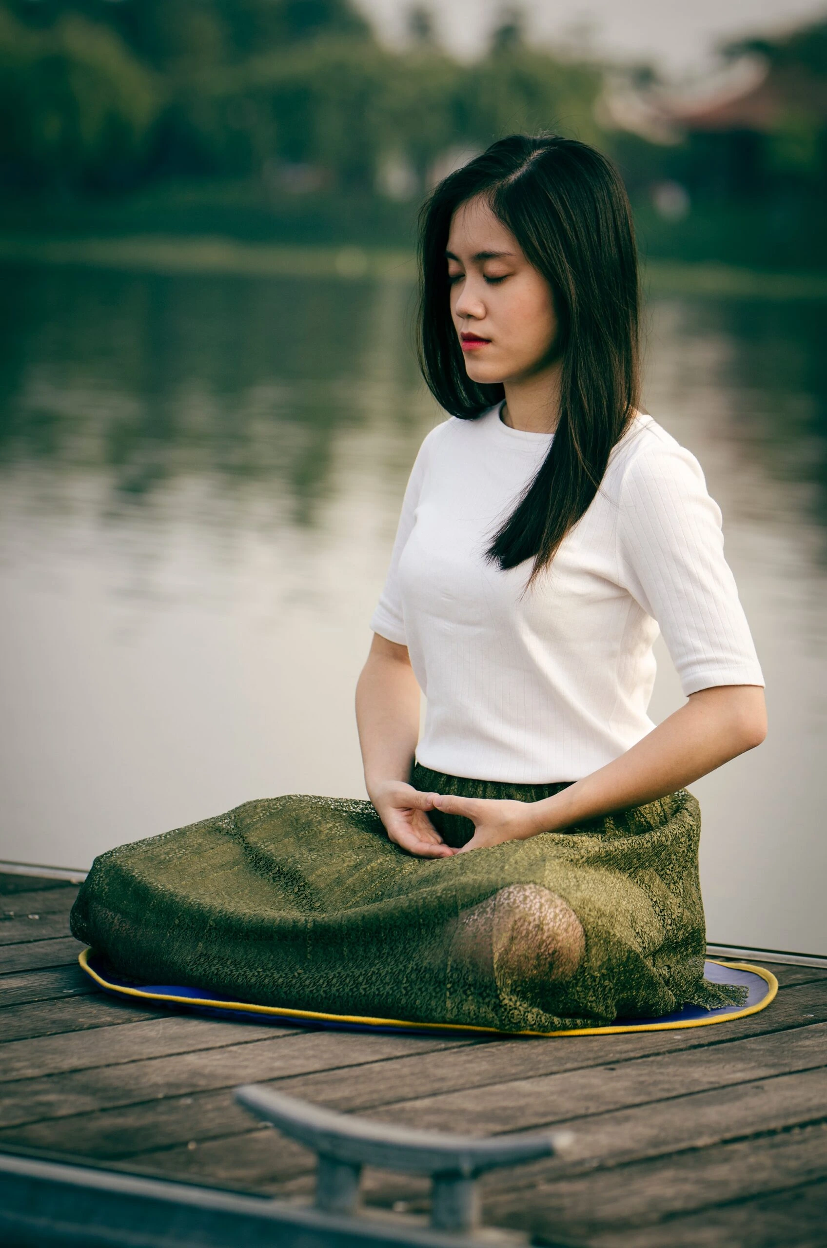 woman on lake dock meditating Le Minh Phuong photographer from Unsplah.