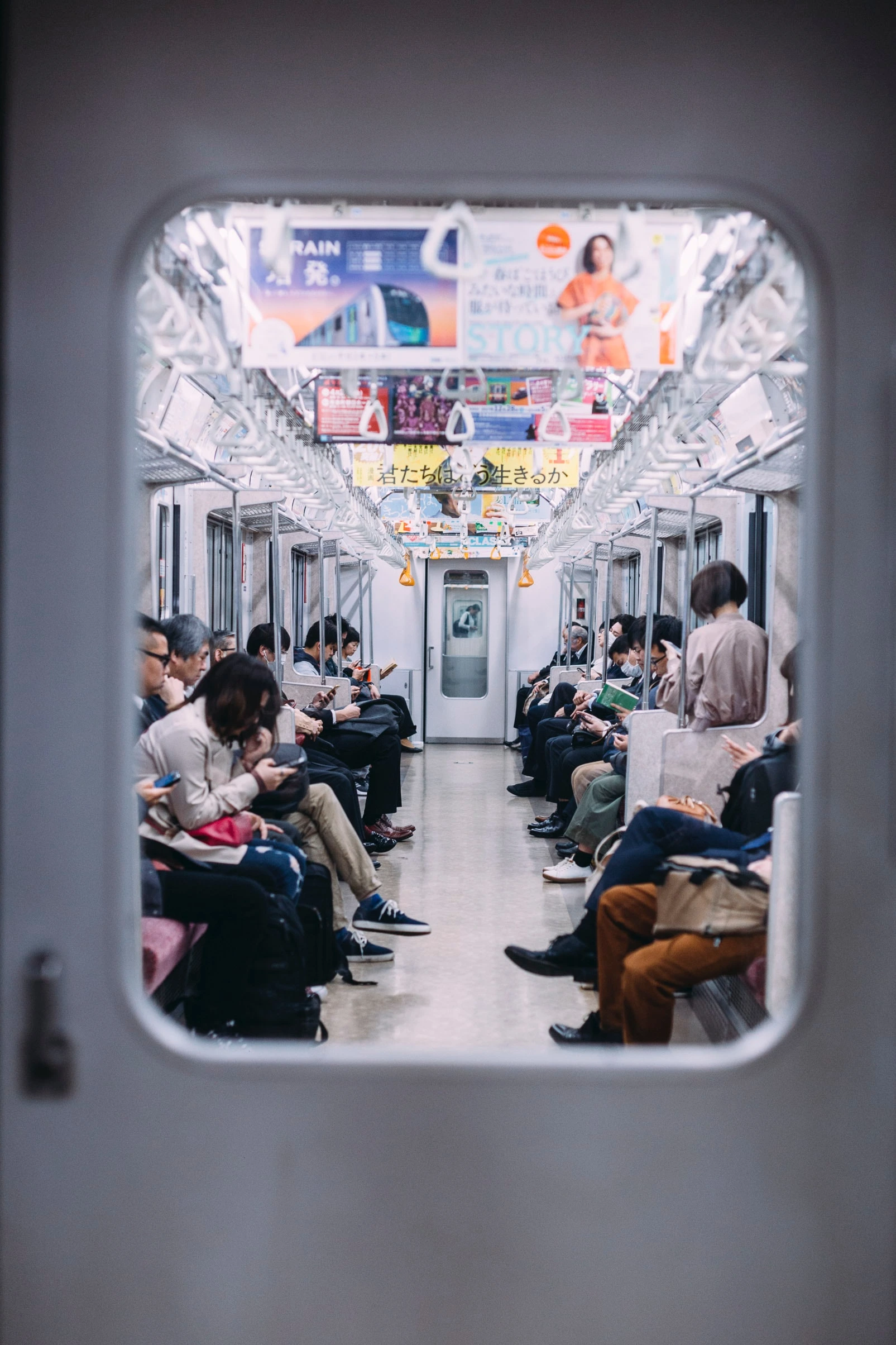 liam-burnett-blue--Tokyo Japan subway interior with commuters-unsplash