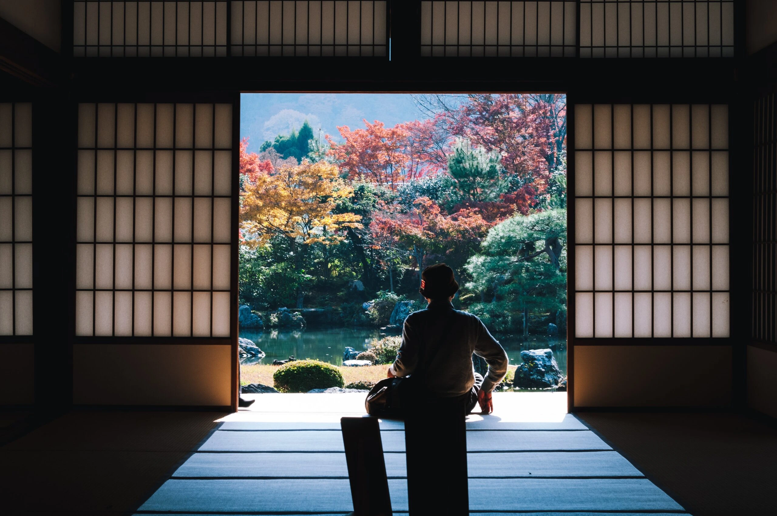 masaaki-komori-Gentleman sitting in Tea house looking out over pond-unsplash