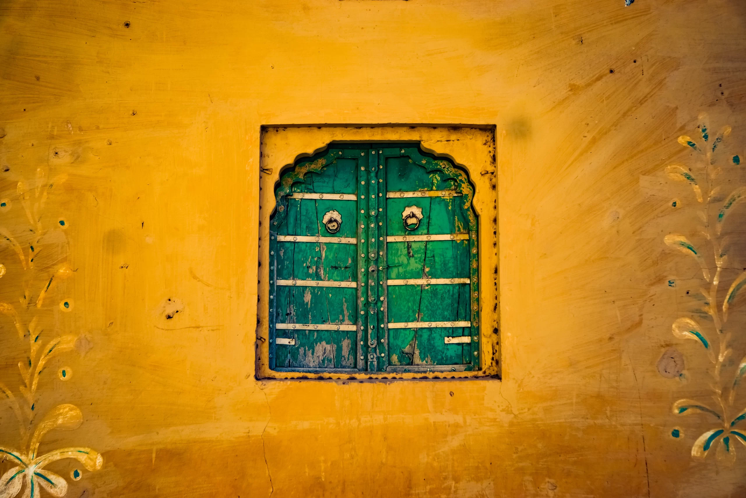 abhinav-srivastava-Orange Adobe edifice with recessed window shutters closed India-unsplas