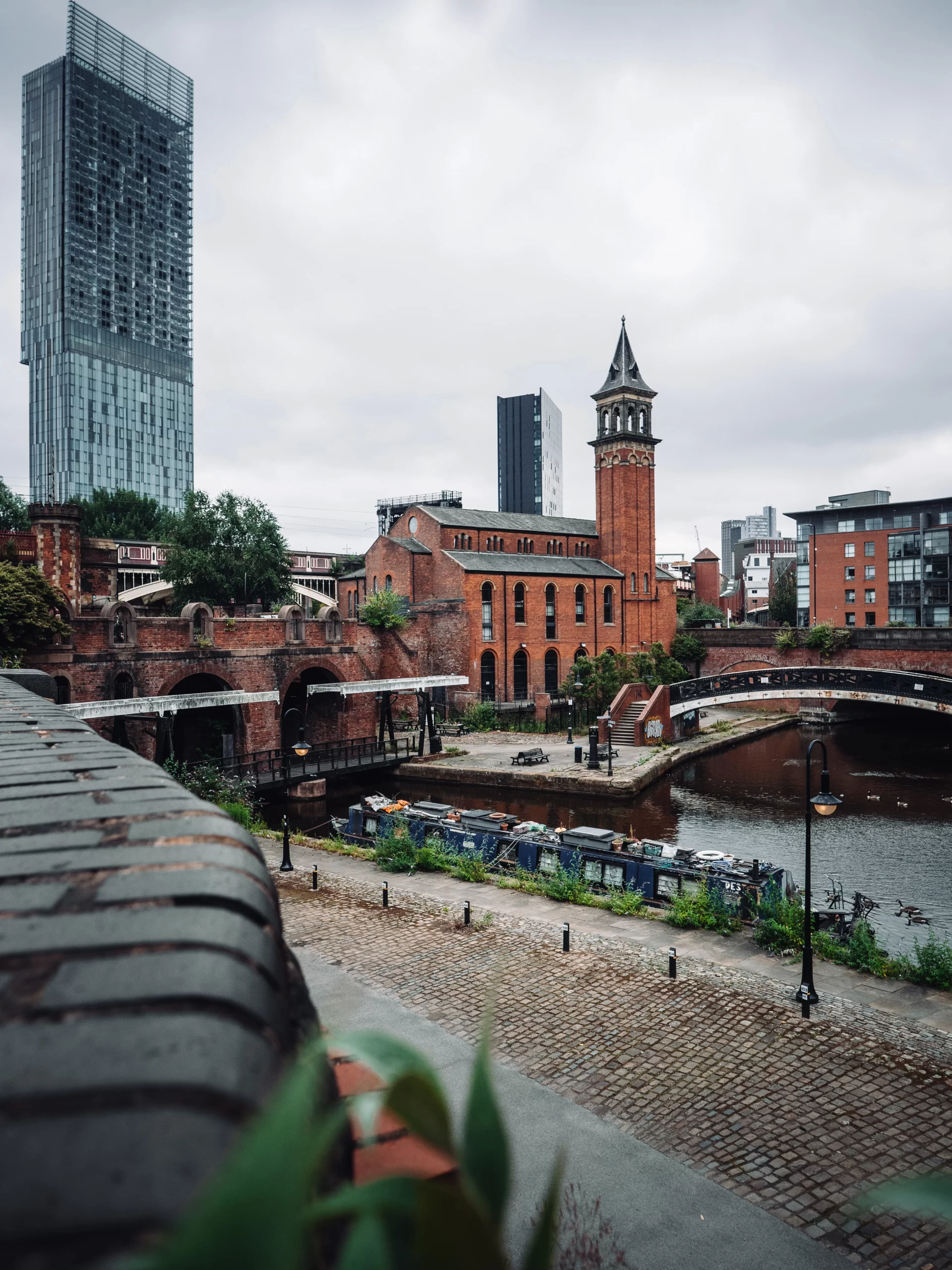 chris-curry-Manchester walkway along river and view of church in background-unsplash