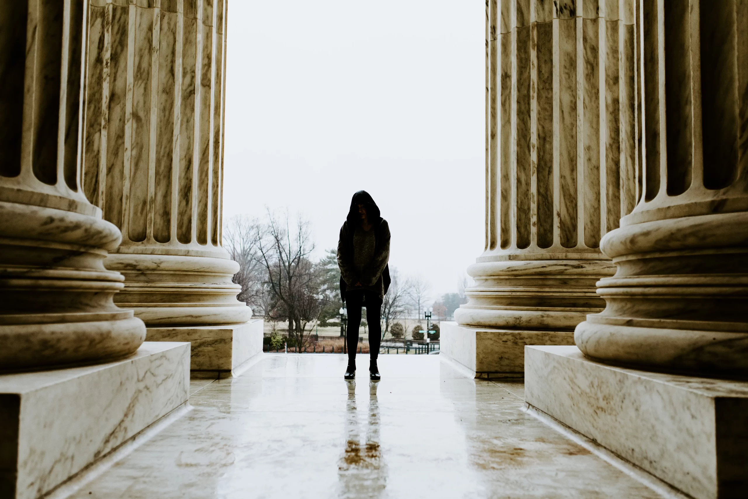 zach-camp-Woman standing between the supreme court columns outside building -unsplash